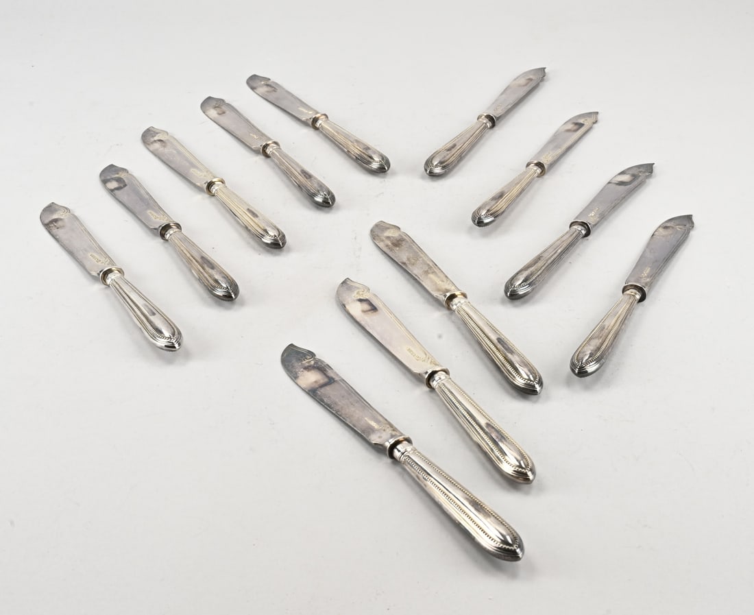 12 Plated knives: Twelve knives, silver-plated, with handles featuring beadwork and blades engraved with floral decoration. 23.5 cm. Total 865 grams. In good condition.