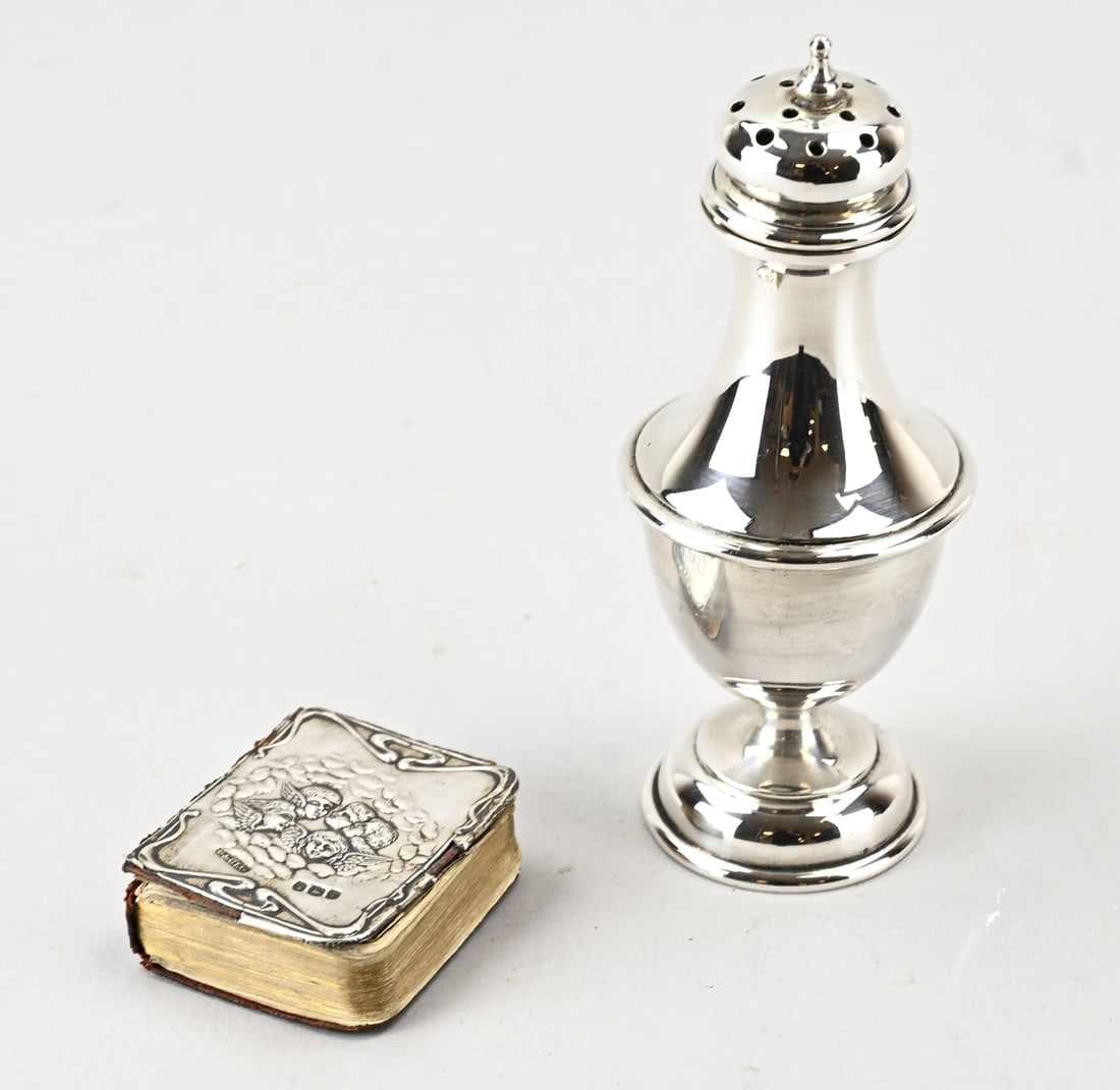 2 Pieces of silver, booklet & shaker: Two pieces of silver, 925/000, with a sugar box and a prayer book with a silver shield decorated with an image of putti; the silver part is loose. Total approx. 70 grams. 4.5 x 15 cm. In good
