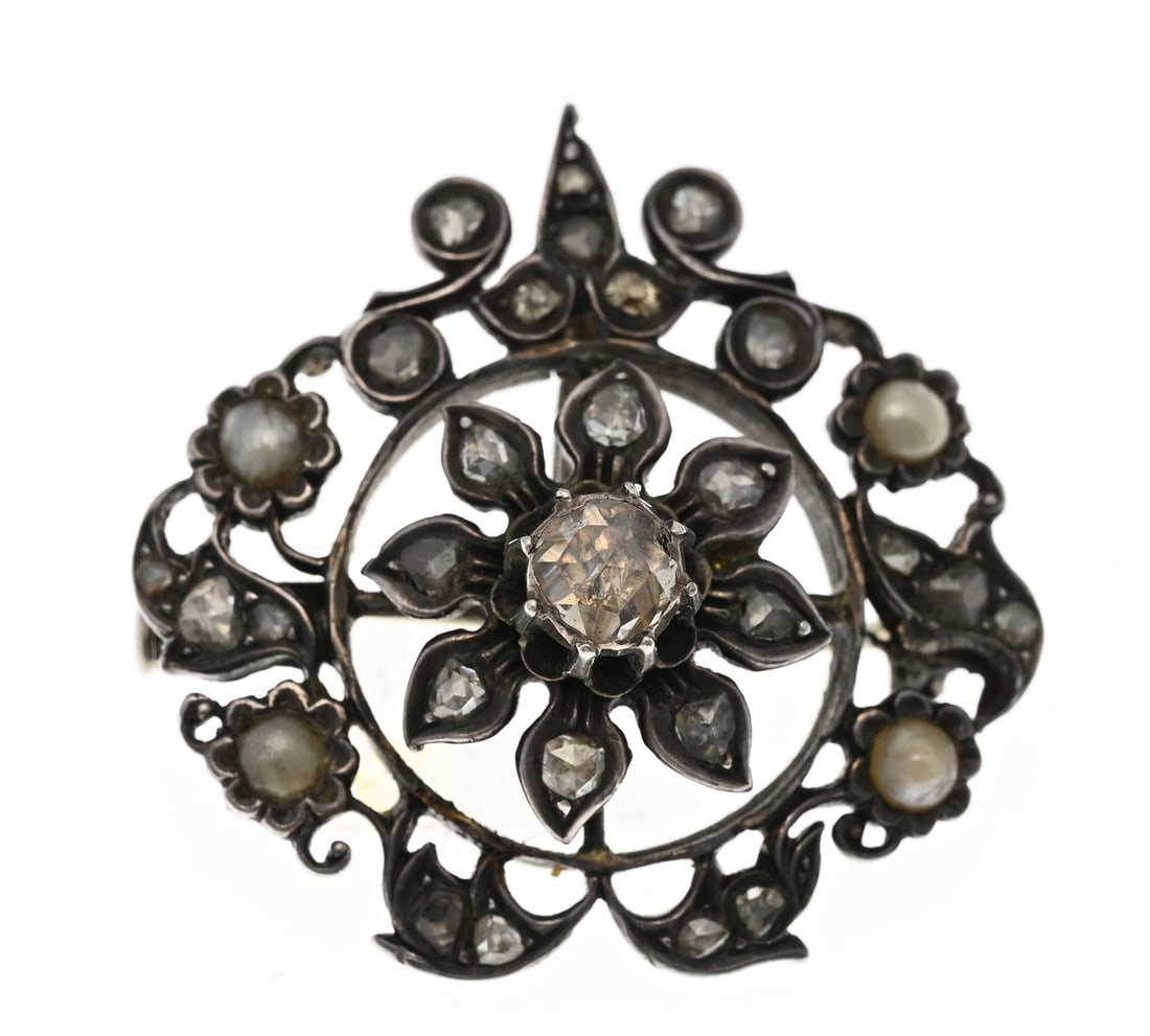 Brooch/ pendant with pearl and diamonds: Silver brooch/pendant with diamonds and pearls. Oval openwork design with a center rosette of rose-cut diamonds surrounded by a rim set with pearls and diamonds. 32x32mm. Approx. 10 grams. In good
