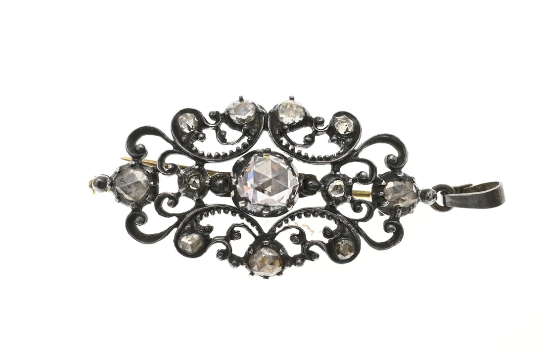 Brooch with silver gold diamond: Brooch, pendant, silver with gold, oval openwork design set with Bolswick-cut diamonds, approx. 3-6.5 mm. Size 22x42mm. Approx. 6.5 grams. In good condition.