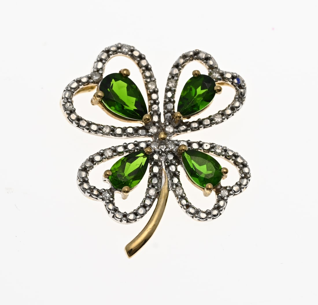 9 carat Clover pendant: Clover-shaped pendant, 375/000, set with 4 pear-shaped green stones and an engraved rim with 12 small diamonds. 19x22mm. Approx. 2.0 grams. In good condition.