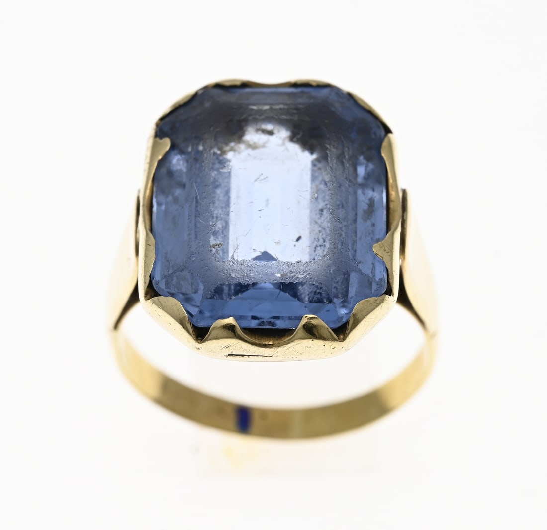 Gold ring with blue stone: Yellow gold ring, 585/000, with blue stone. Ring with a large rectangular setting with a blue faceted stone, wear along the facet lines. Approx. 8.6 grams. Head width 19.5 mm. ø 60. In