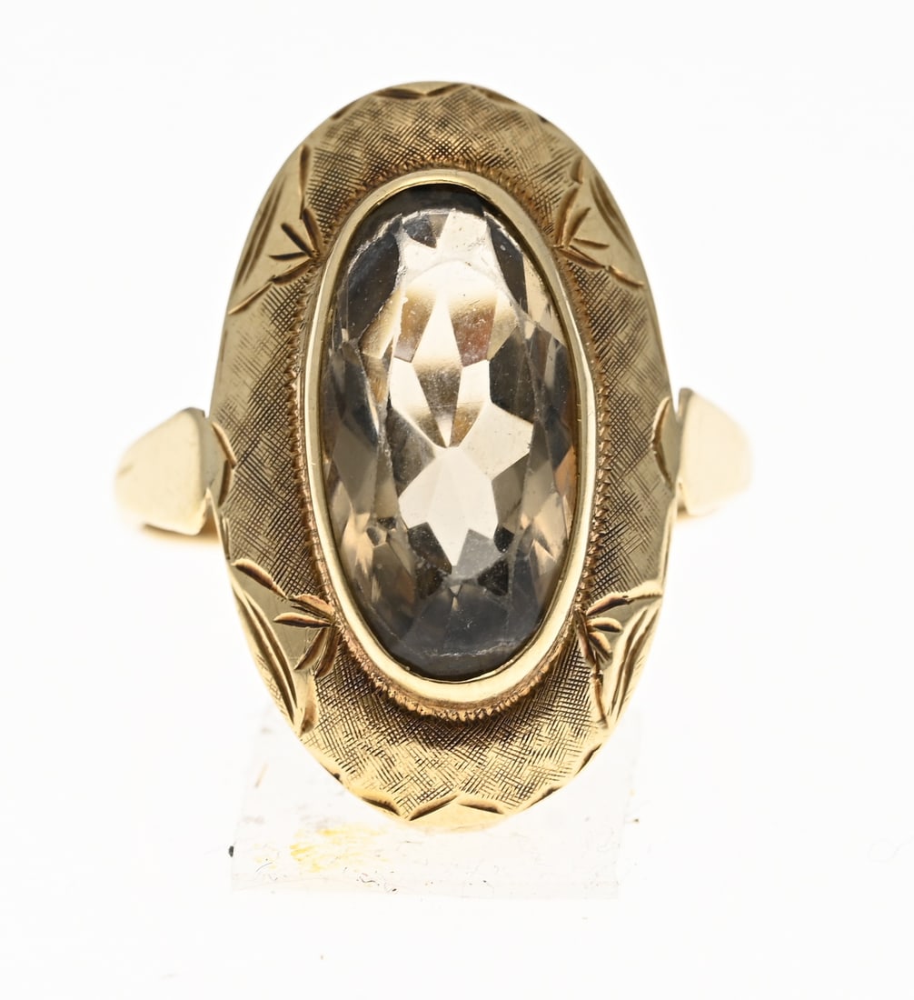 Gold ring with a smoky quartz: Yellow gold ring, 585/000, with smoky quartz. Ring with an oval-worked setting with engraved decoration, set with an oval-faceted smoky quartz. Head width 23 mm. ø 54. Approx. 3.7 grams. In good