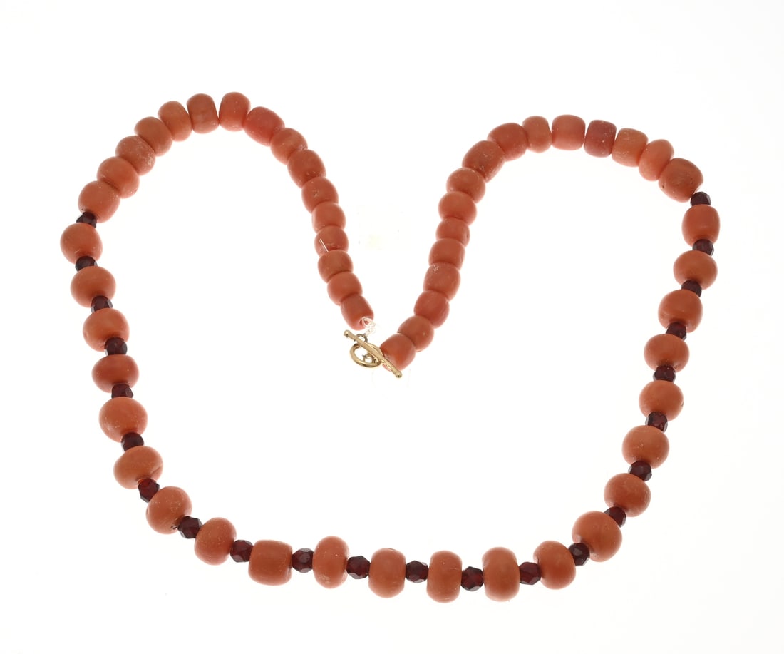 Blood coral necklace: Red coral necklace with garnet and a yellow gold thong and loop, 585/000. Red coral necklace, ø6.5-10 mm. Decorated in the center with faceted garnet stones. Length 36 cm. Approx. 53.4 grams. In