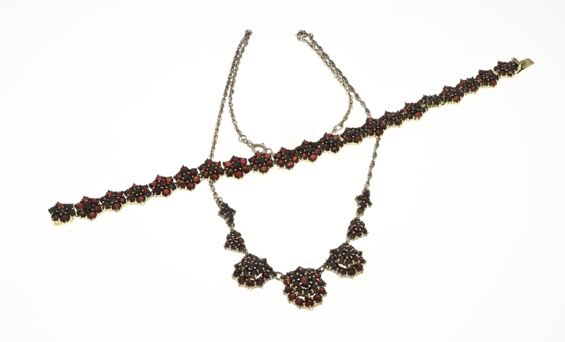 Lot of jewelry with garnet: A silver choker, 835/000, and a double bracelet with garnets. A twisted necklace with 3 rosettes with garnets and 4 small ones in the center. And a bracelet with rosette-shaped links with garnets.
