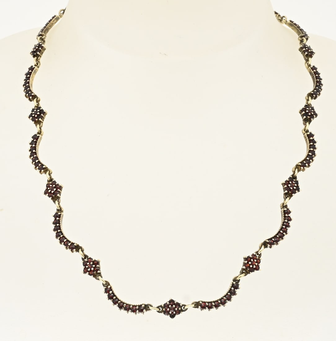 Choker with grenade: Gold-plated choker, 925/000, with garnet stones. Choker made of semi-circular and diamond-shaped links set with garnet stones. Length 42 cm. Approx. 18.8 grams. In good condition.