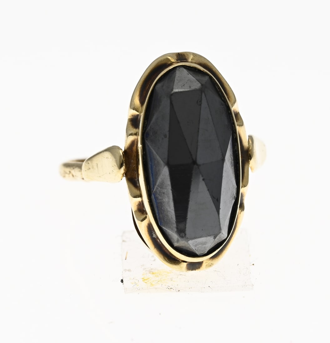 Gold ring with hematite: Yellow gold ring, 585/000, with hematite. Ring with an oval setting set with an oval faceted hematite stone. Head width 20 mm. ø 55. Approx. 4.8 grams. In good condition.