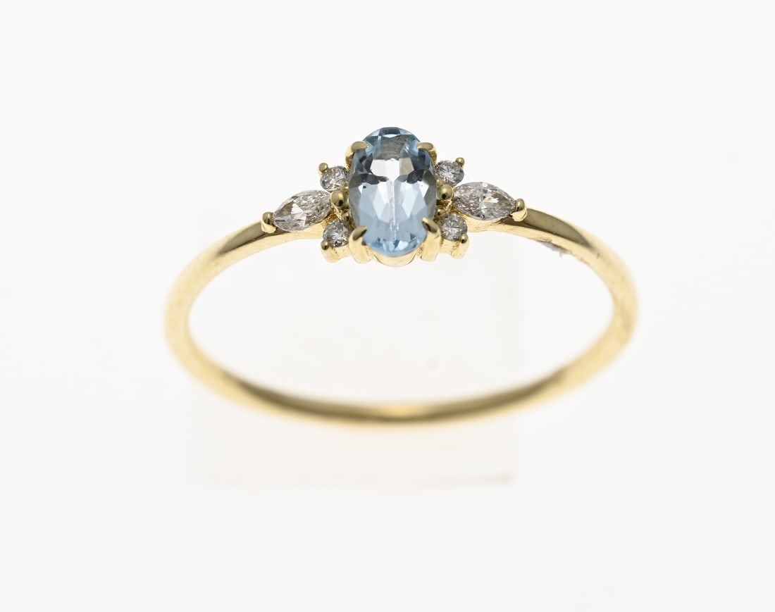 Gold ring with light blue topaz and diamond: Yellow gold ring, 585/000, with diamond and blue topaz. Delicate ring with an oval faceted blue topaz in the center, flanked by 2 marquise-cut diamonds and 4 small brilliant-cut diamonds. Head width 5