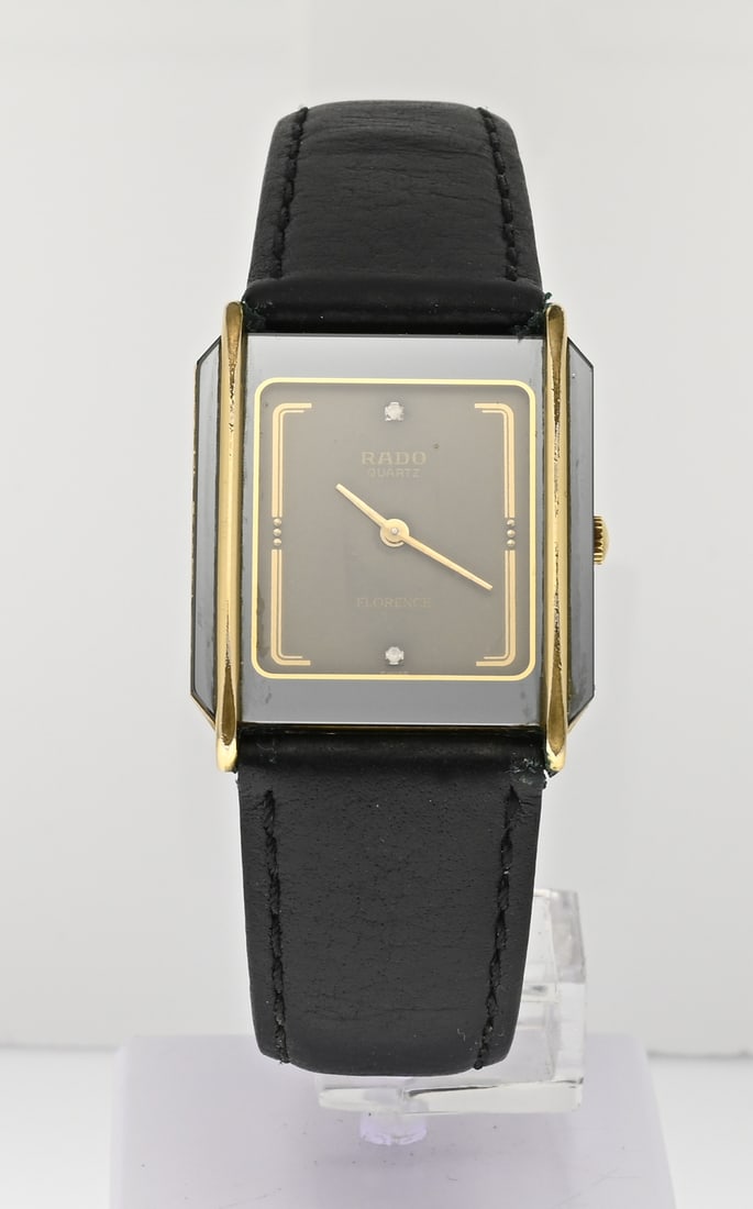 Rado watch black strap: Rado quartz Florence watch, with a bicolour rectangular case. Case width 25 mm. Case number: 3531532. Scratch on the glass. Mounted on a black leather strap. Working.