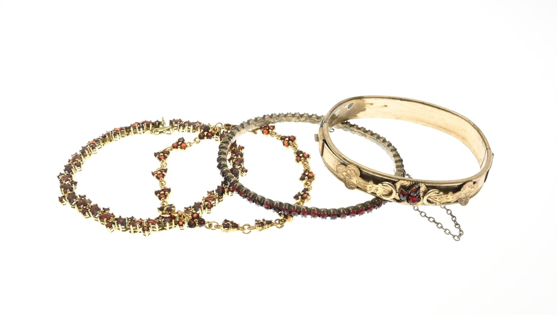 Lot of garnet jewelry: Four pieces of jewelry with garnet: 3 double bracelets, 2 bangles, a link bracelet with garnet stones, and a silver-plated bracelet with triangular links with 3 garnet stones. In good condition.