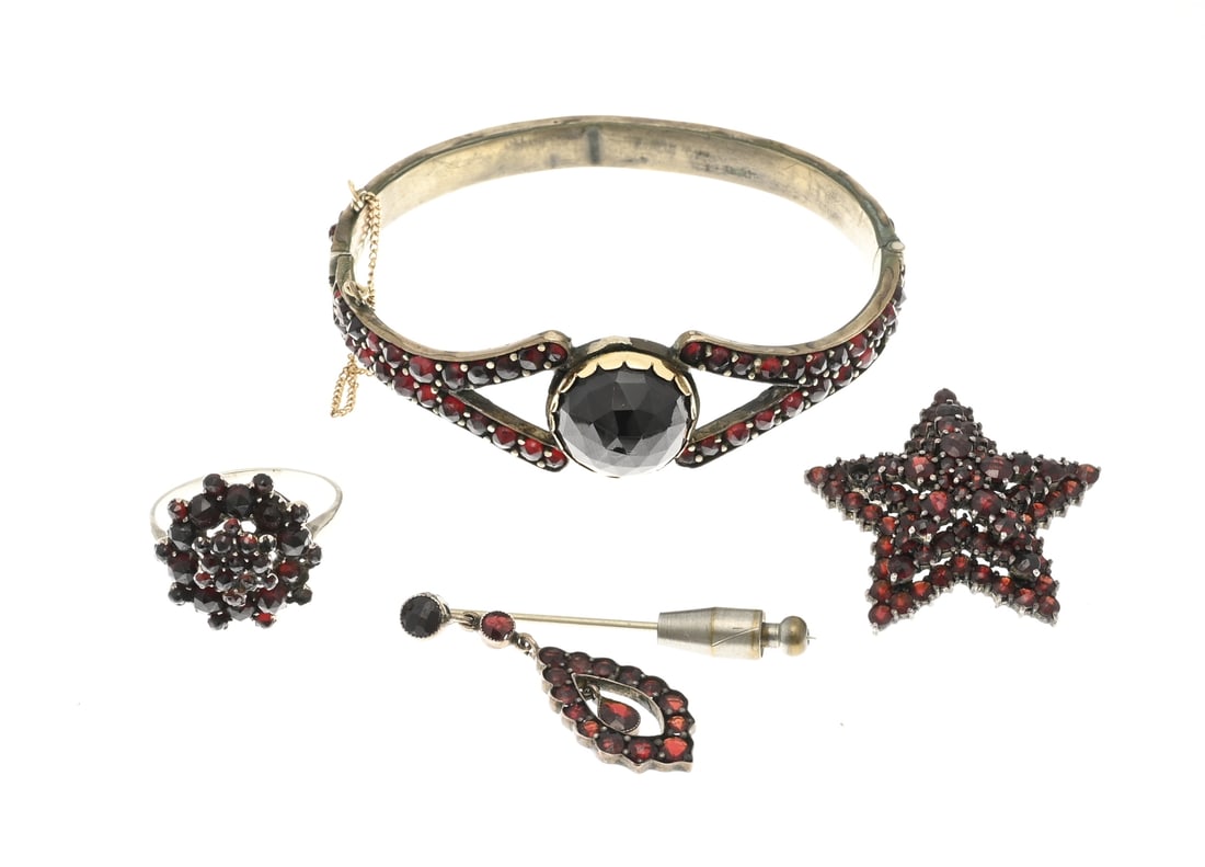 Set of garnet jewelry: Set of jewelry with garnet, a double bangle set with garnet stones, in the center set with a large faceted garnet stone set in a yellow gold bezel. The bangle has a hinge and safety catch. Gold