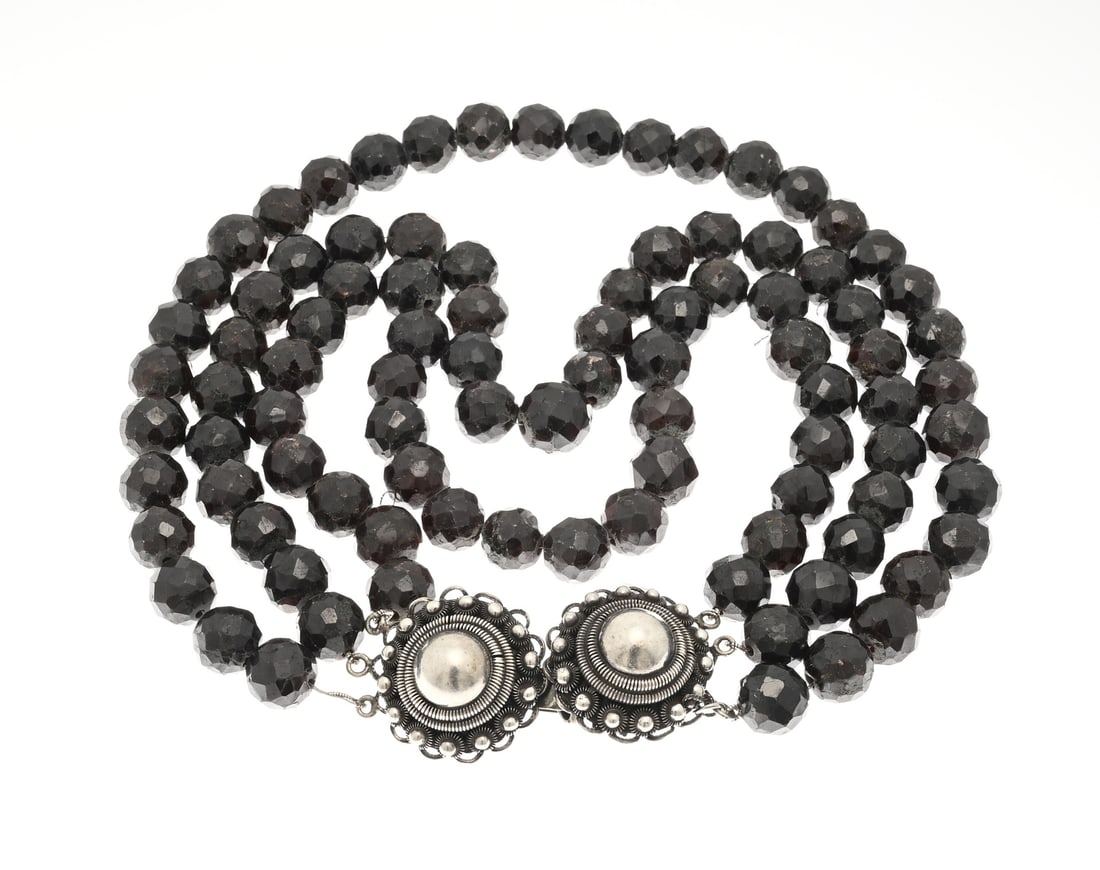 Garnet necklace with silver clasp: Necklace of 3 rows of garnets, ø 12 mm., attached to a silver clasp, 833/000, made from 2 buttons. One loop broken off. Length 40 cm. approx. 316 grams. In reasonably good condition.