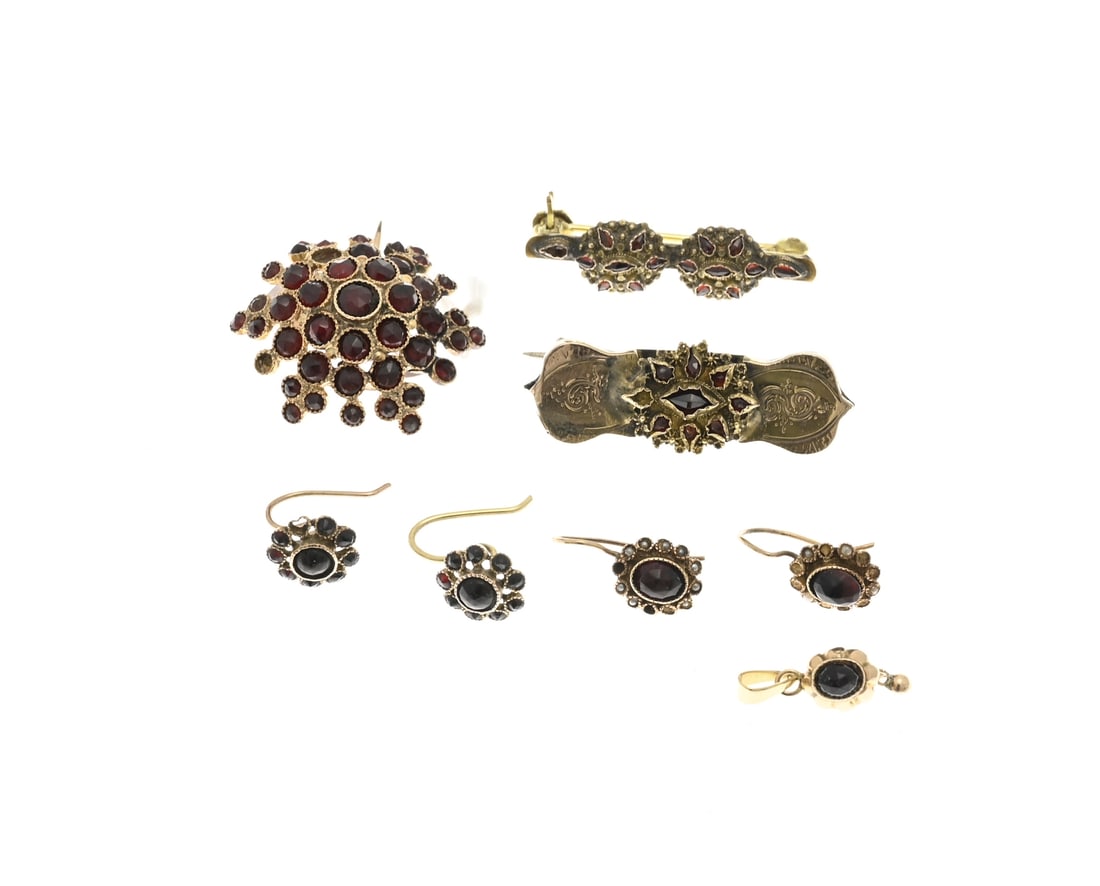 Lot of garnet jewelry: Lot of garnet jewelry with a yellow gold star-shaped brooch with garnets (one is missing), a small yellow gold pendant with an oval garnet, 2 pairs of gold earrings with garnet and pearls (some