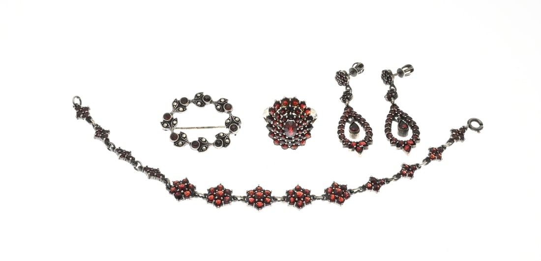 Lot of silver jewelry with garnet: Lot of silver jewelry with garnet. A pair of earrings, a ring, a brooch, and a bracelet with garnet stones. Approx. 21.4 grams. Various purities. In good condition.
