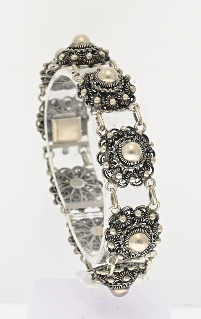 Silver bracelet with buttons: Silver bracelet, 835/000, with 9 Zeeland buttons. ø 16.5 mm. With box clasp. Length 19 cm. Approx. 27.3 grams. In good condition.