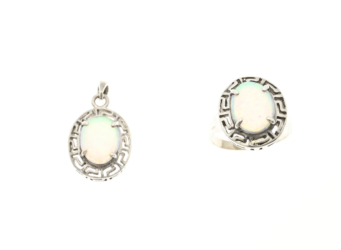 Silver ring and pendant with opal: Silver ring and pendant, 925/000, with opal. Ring with oval head and oval pendant with a meander design and an oval white/bluish opal. 20x17mm. ø 60. Approx. 9.2 grams. In good condition.