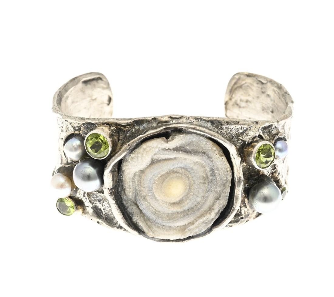 Handmade silver bangle: Silver cuff, 925/000, handmade, irregularly shaped, tapering in width, decorated with a geode in the center. Pearls and peridot stones are set on both sides. Width 34 mm. ø approx. 59x43 mm.