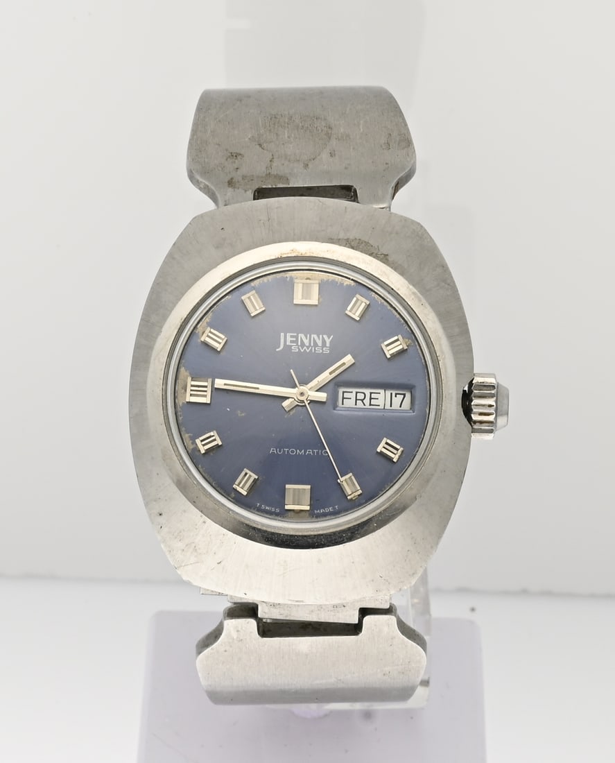 Vintage watch: Vintage steel watch, Jenny Swiss, automatic, with a contoured case, blue dial with day and date display. Case diameter 36 mm. Case number 1951. With elegant steel bracelet. Working. Shows signs of