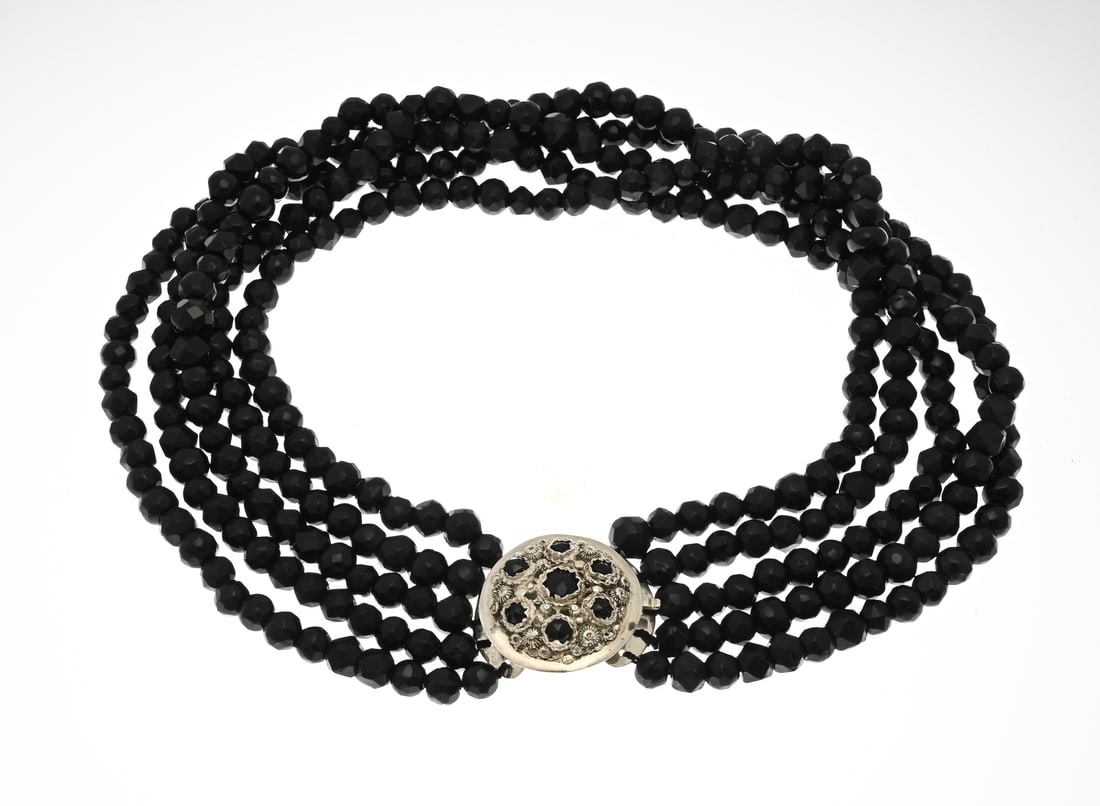 5-strand jet necklace: Necklace with jet beads and a silver regional clasp, 835/000. Necklace with 5 rows of faceted beads, ø 9 mm., attached to a round silver regional clasp with filigree, twisted edges, buttons, and