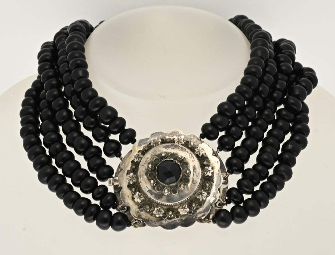 5-strand jet necklace: Necklace with jets and a silver regional clasp, 835/000. Necklace with 5 rows of round beads, ø 8 mm., attached to a round silver regional clasp with filigree, star appliqués, buttons, and