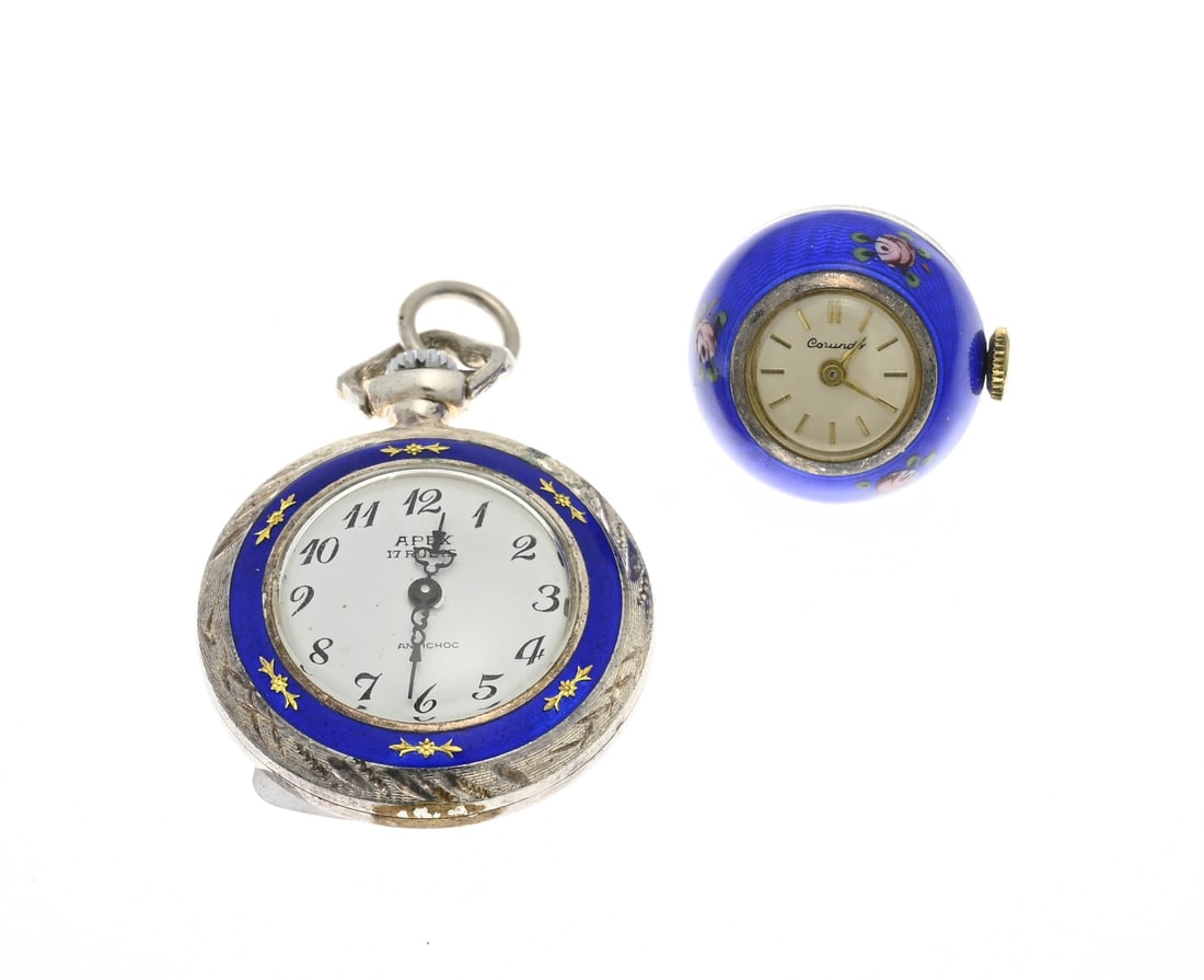 2 Small pendant clocks: Two small pendant clocks richly decorated with blue enamel. Both mechanical. A flat clock: Apex, ø 30mm., and a ball clock with floral decoration. Corundo. ø 20 mm. Working, in good conditio