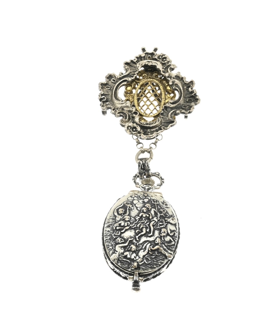 Silver watch with skirt hook: Fine silver pendant clock on a skirt hook, 835/000. Oval clock with a lid decorated with figures. Attached to a contoured skirt hook with lobes, volutes, and lattice work. Approx. 86 grams. 12.2 cm.