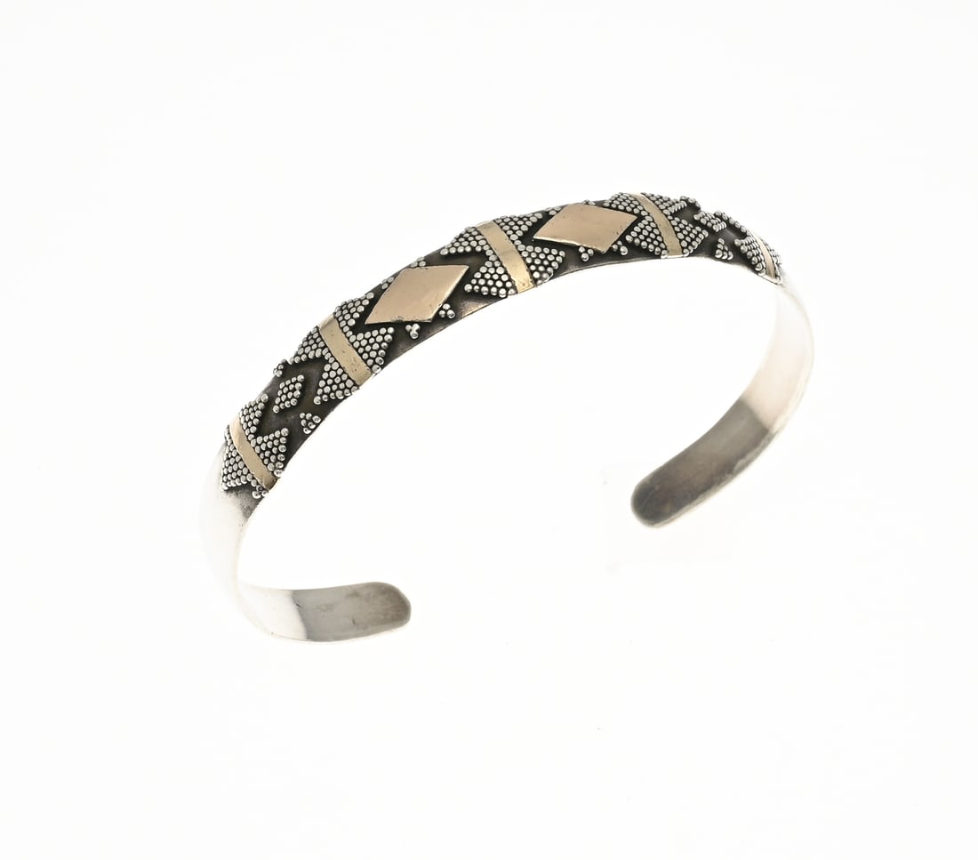 Silver bangle with gold element: Silver bangle, 925/000, with decorations of grains and diamonds and elongated gilded elements. ø46x59mm. Width 9 mm. Approx. 15.7 grams. In good condition.