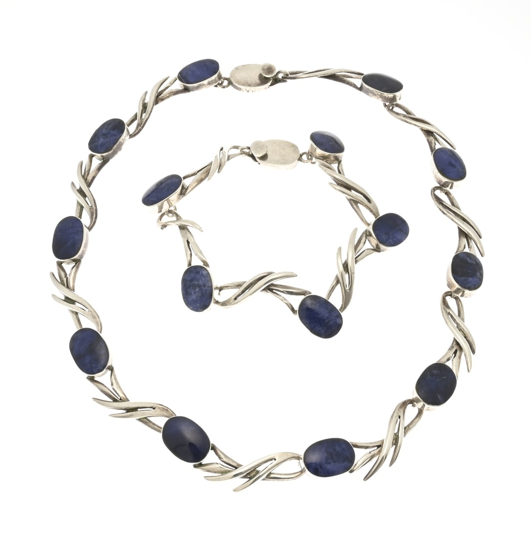 Silver choker and bracelet: Silver choker and bracelet, 925/000, with lapis lazuli. Choker and bracelet with floral-shaped links and oval settings, each set with a cabochon-cut lapis lazuli stone. Width 21 mm. Length 18.5-41