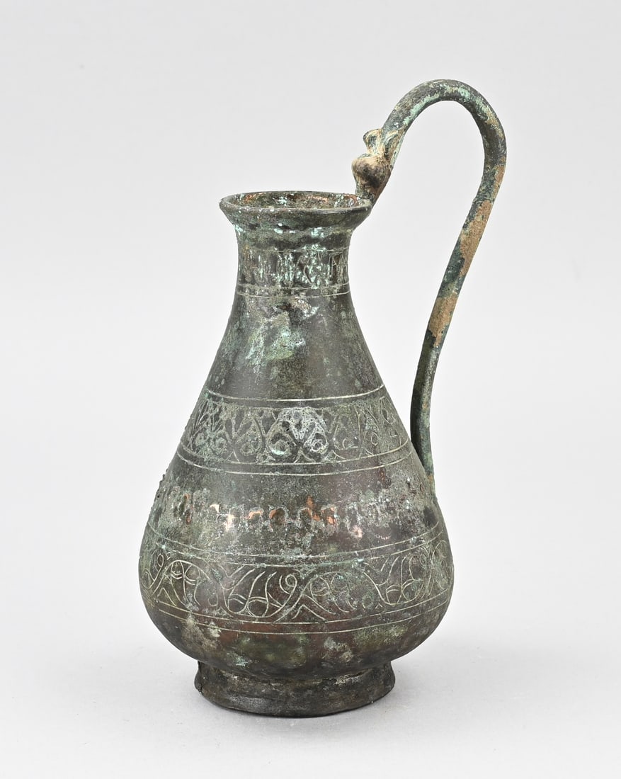 Antique bronze pitcher: Antique Persian bronze pitcher. Circa 1300. Handle reattached. Geometric decoration all around. Dimensions: H 23 cm. In good condition.