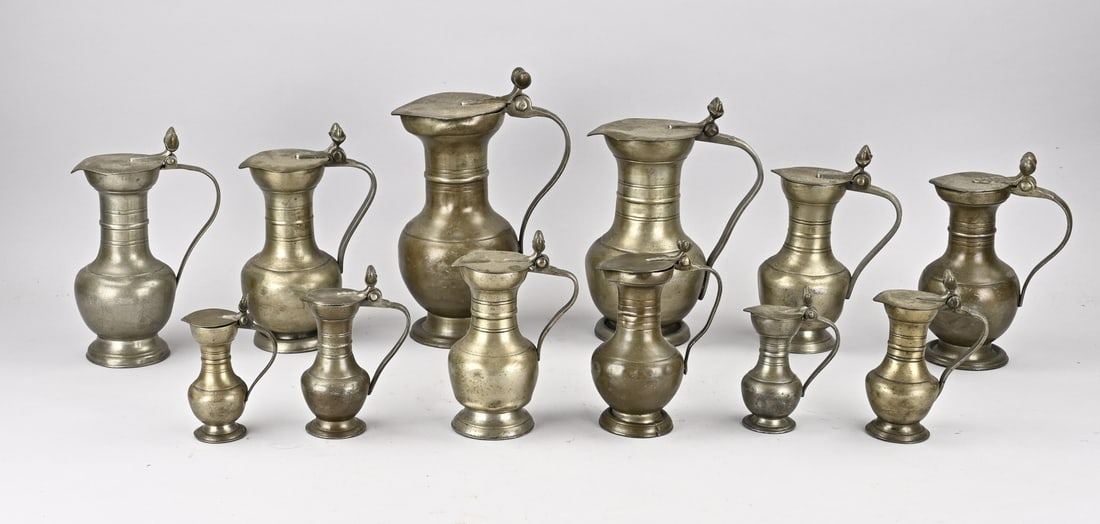 Lot of pewter measuring jugs: Large lot of antique pewter measuring jugs with base marks + lid marks + acorns on the lid. Base mark HG + crown. Dimensions: 14 - 27 cm. In good condition.