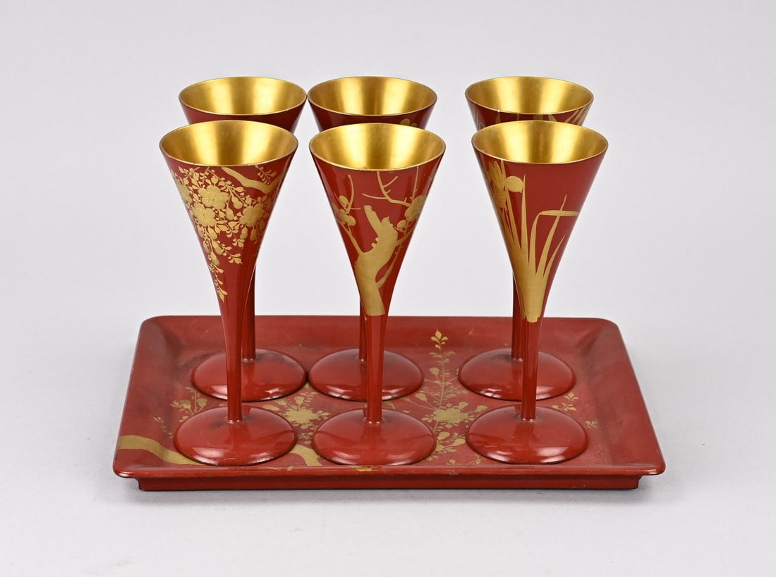 6x Japanese lacquer flutes + tray: Seven-piece antique Japanese champagne lacquerware set with floral gold decoration. Dimensions: 14 x 26 x 19 cm. In good condition.