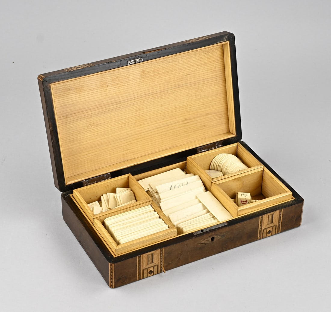 Box with bone tokens, 1900: Antique burr walnut lidded box, filled with bone game tokens. Circa 1900. Dimensions: 6.5 x 27 x 15 cm. In good condition.