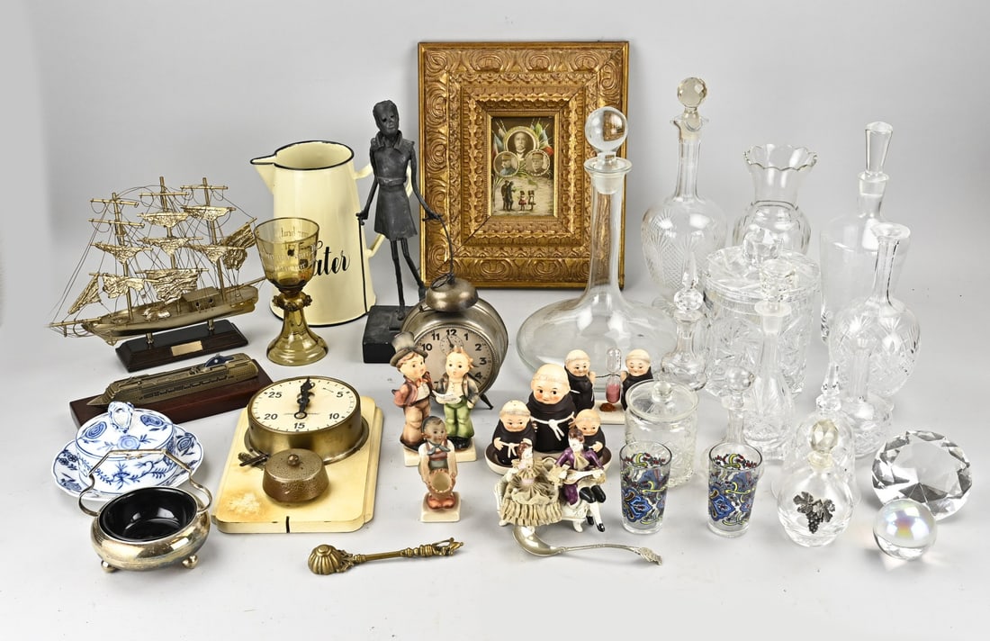 Box with miscellaneous items: Box full of miscellaneous items. Including: glass carafes, picture frame, alarm clocks/clocks, biscuit tin, Hummel/Goebel figurine, et cetera. In reasonably good condition.