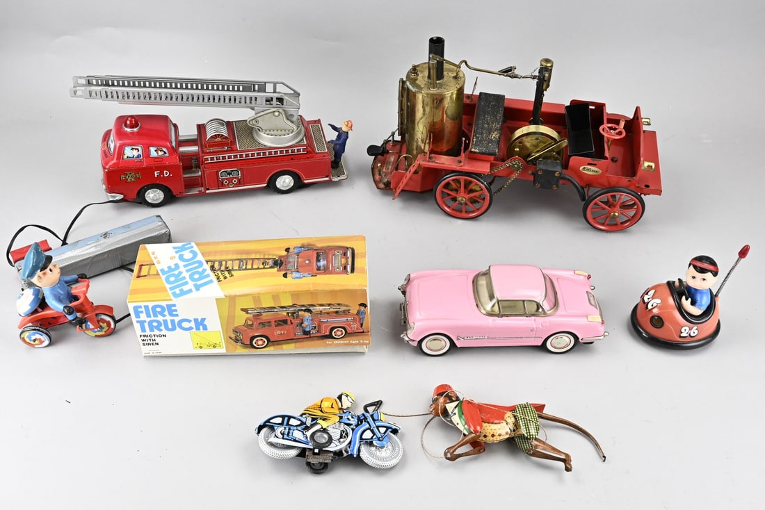 Lot of tin toys: Lot with eight pieces of miscellaneous toys. Including: a steam-powered tin fire truck, a tin fire truck with controls, a tin fire truck with original packaging, a climbing monkey, a motorcyclist, a p