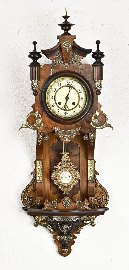 Balcony swing: Walnut balcony pendulum with bronze decorations. Week runner with half-hour strike on a gong spring. Antique movement. Marked BP. Dimensions: 86 cm. In good condition.