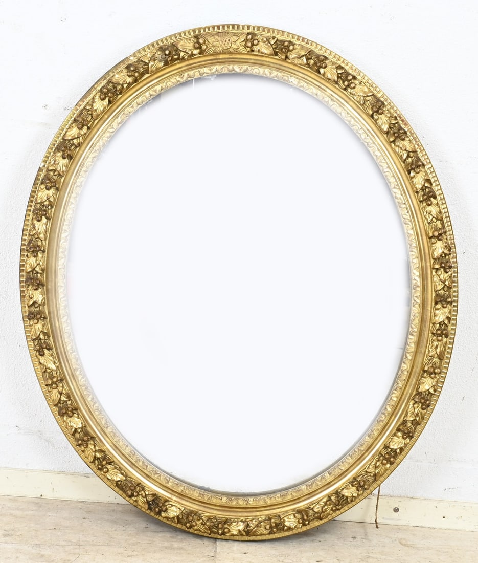Mirror: Antique, oval gilded mirror with relief vine decoration. Dimensions: 80 x 91 cm. In good condition.