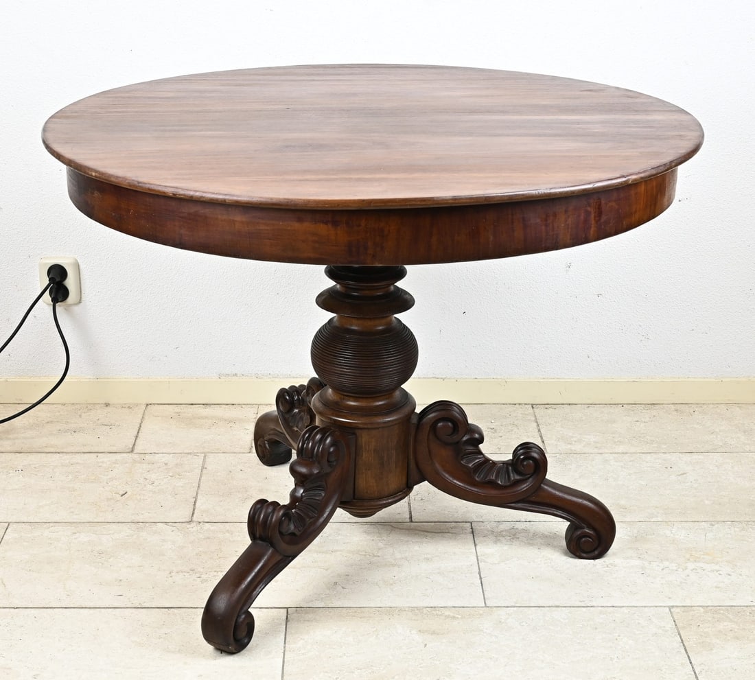 Mahogany Biedermeier dining table: 19th-century round mahogany dining table with carved three-span legs. Circa 1860. Dimensions: H 76 x Ø 101 cm. In good condition.