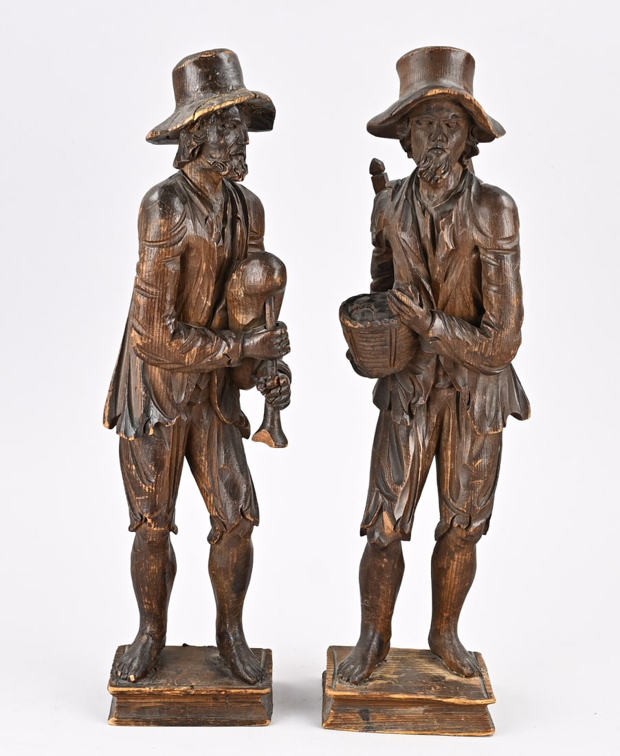 Two woodcarved figures, Peddlers: Two 18th-century softwood carved peddlers. Dimensions: H 40 - 41 cm. Hat slightly damaged. In fair/good condition.