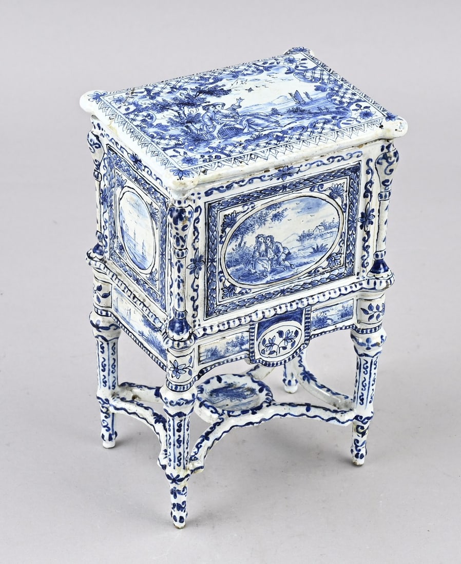 Antique Delft miniature furniture: Antique Delft faience miniature cabinet with landscape decoration. With base mark HN. Dimensions: 21 x 13 x 9 cm. One leg repaired. One corner of the lid glued. In good condition.