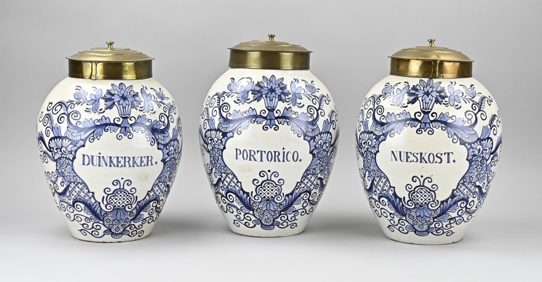 3x Antique tobacco jar + lid: Set of three antique Delft tobacco jars with copper lids. 19th century. Dimensions: H 30 cm. In good condition.