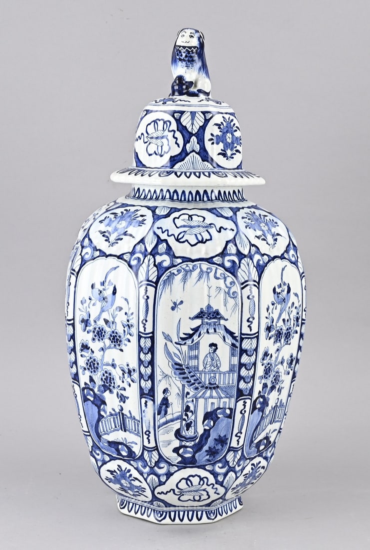 Delft lidded vase, H 51.5 cm.: Antique, octagonal Delft lidded vase with chinoiserie/stage backdrops + lion decoration. Dimensions: H 51.5 cm. In good condition.