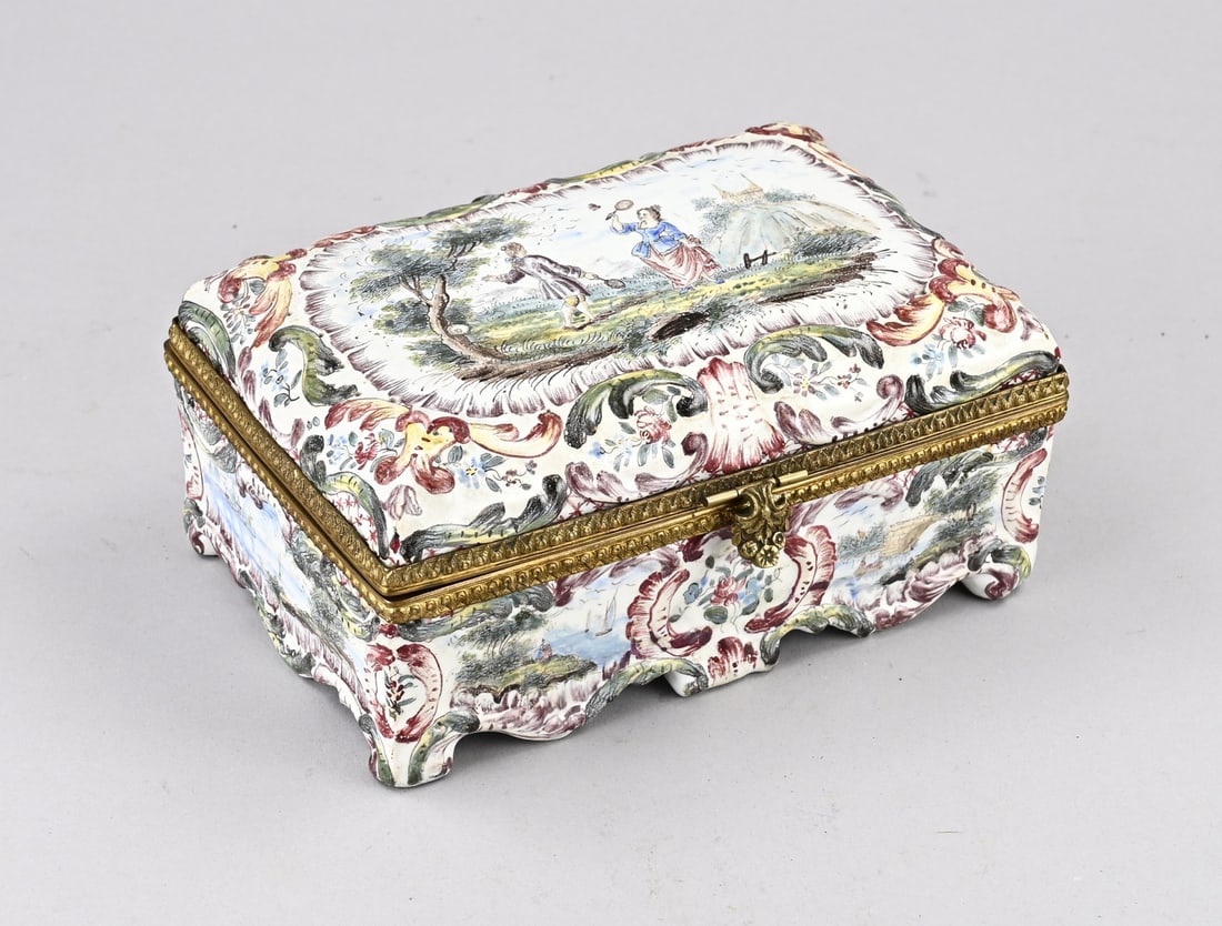 Porcelain lidded box: Antique French polychrome faience lidded box with badminton players/floral decoration. Marked Fleur de lis. With lily base mark. Dimensions: 9 x 20 x 14 cm. In good condition.