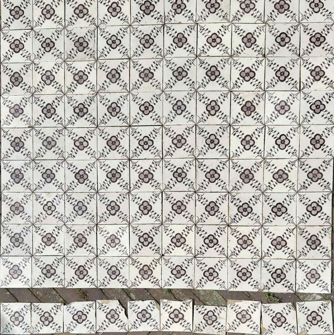 Lot with 100 antique tiles: Lot of 100 antique cross-rose tiles with corner motif. In the shape of ox heads. Color: manganese. Made by vanTraa Rotterdam. Circa 1825 - 1850. Also includes 10 extra tiles with damage. Dimensions: