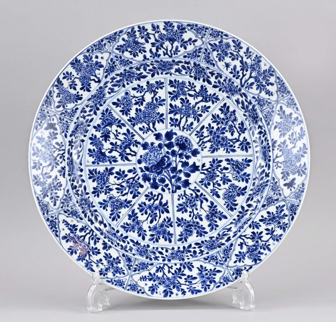 Large Kang Xi dish Ø 39 cm.: Very large 17th-18th century Chinese porcelain Kang Xi dish with floral/peony decoration. With base mark. Restored. Retouched hairline cracks. Dimensions: Ø 39 cm. In good condition.