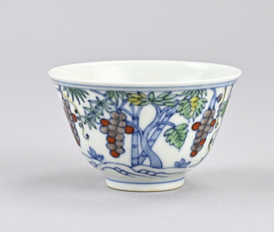 Doucai cup: Chinese porcelain Doucai cup with grapevine decoration. Six-character base mark. Dimensions: H 4.7 x Ø 7.4 cm. In good condition.