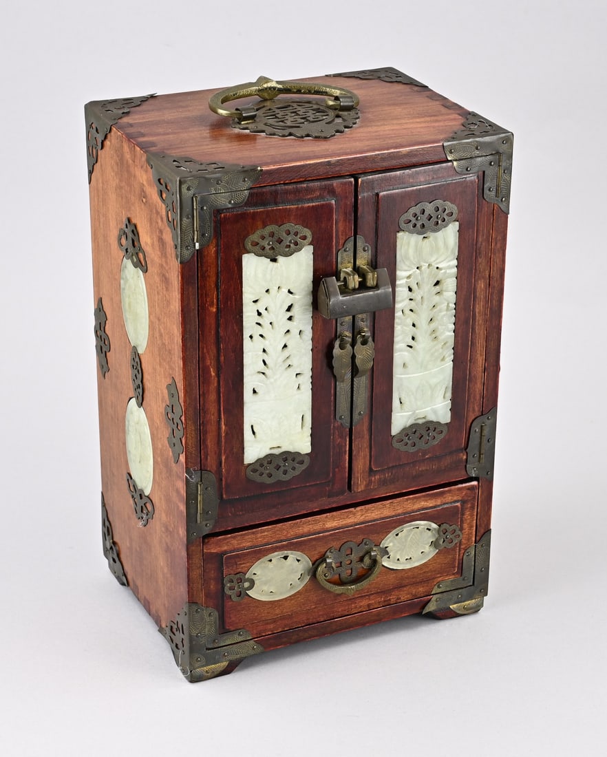 Chinese jewelry box: Old Chinese cherry wood jewelry cabinet with brass fittings and natural stone (jade?) plaques. 20th century. Dimensions: 32 x 20 x 16 cm. In good condition.