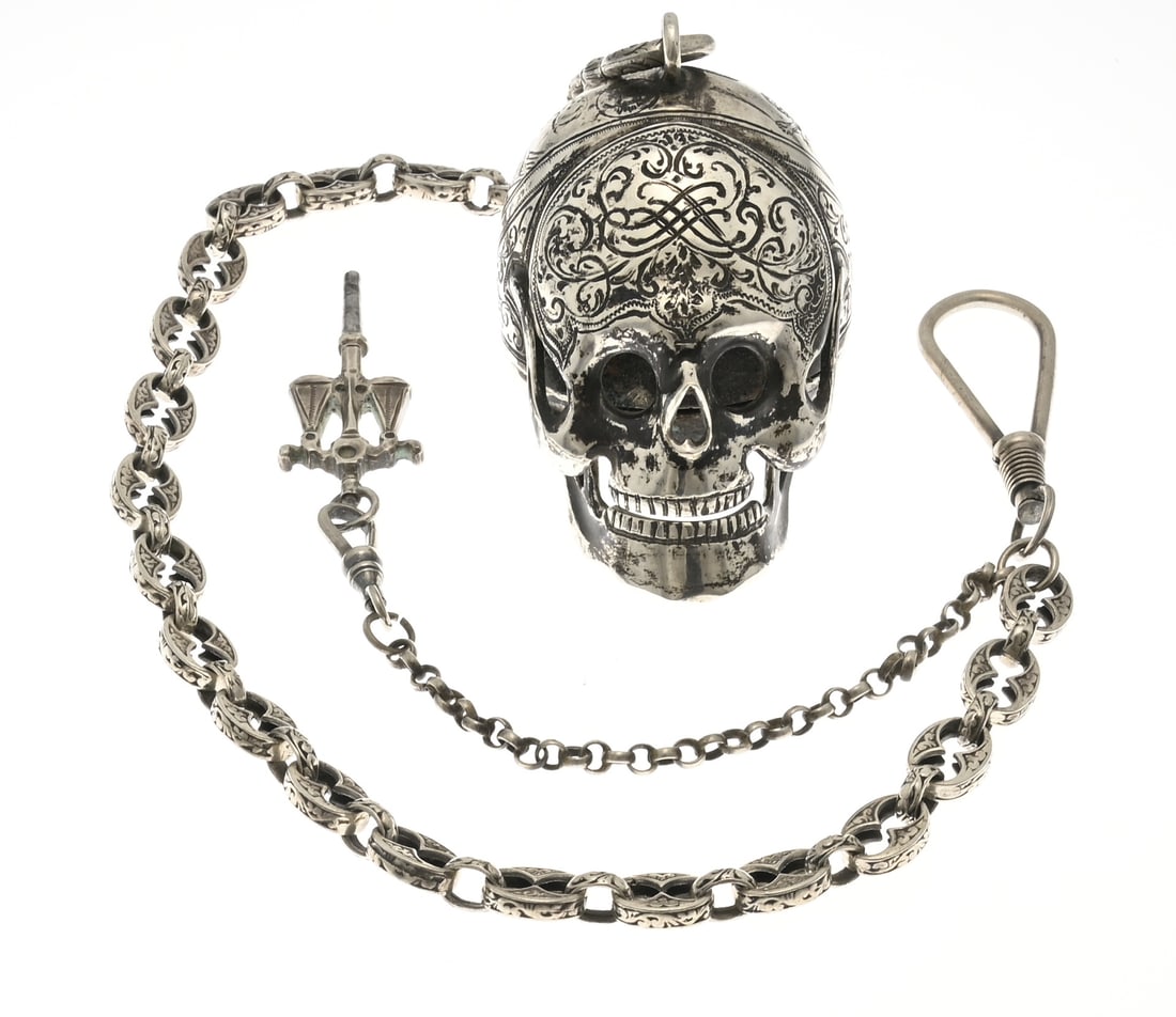 Silver memento mori watch: Exceptional silver memento mori pocket watch. Case in the shape of a skull, richly decorated with engraving. The back features an engraved depiction of figures: a woman with scales, a man with a rod, 