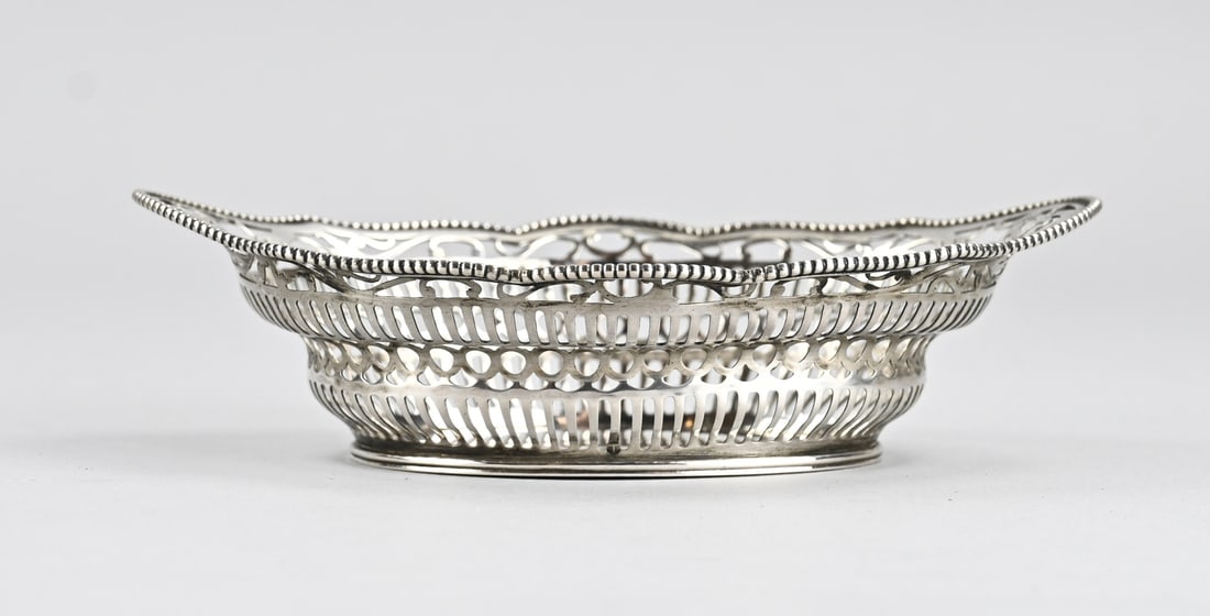 Silver bonbon basket: Silver bonbon basket, 833/000, oval contoured model with sawn bars and floral decoration. Fitted with a beaded rim. MT.: CFWewer, Schoonhoven, jl.:T:1929. 14.5x10.5x4cm. approx. 68 grams. In good