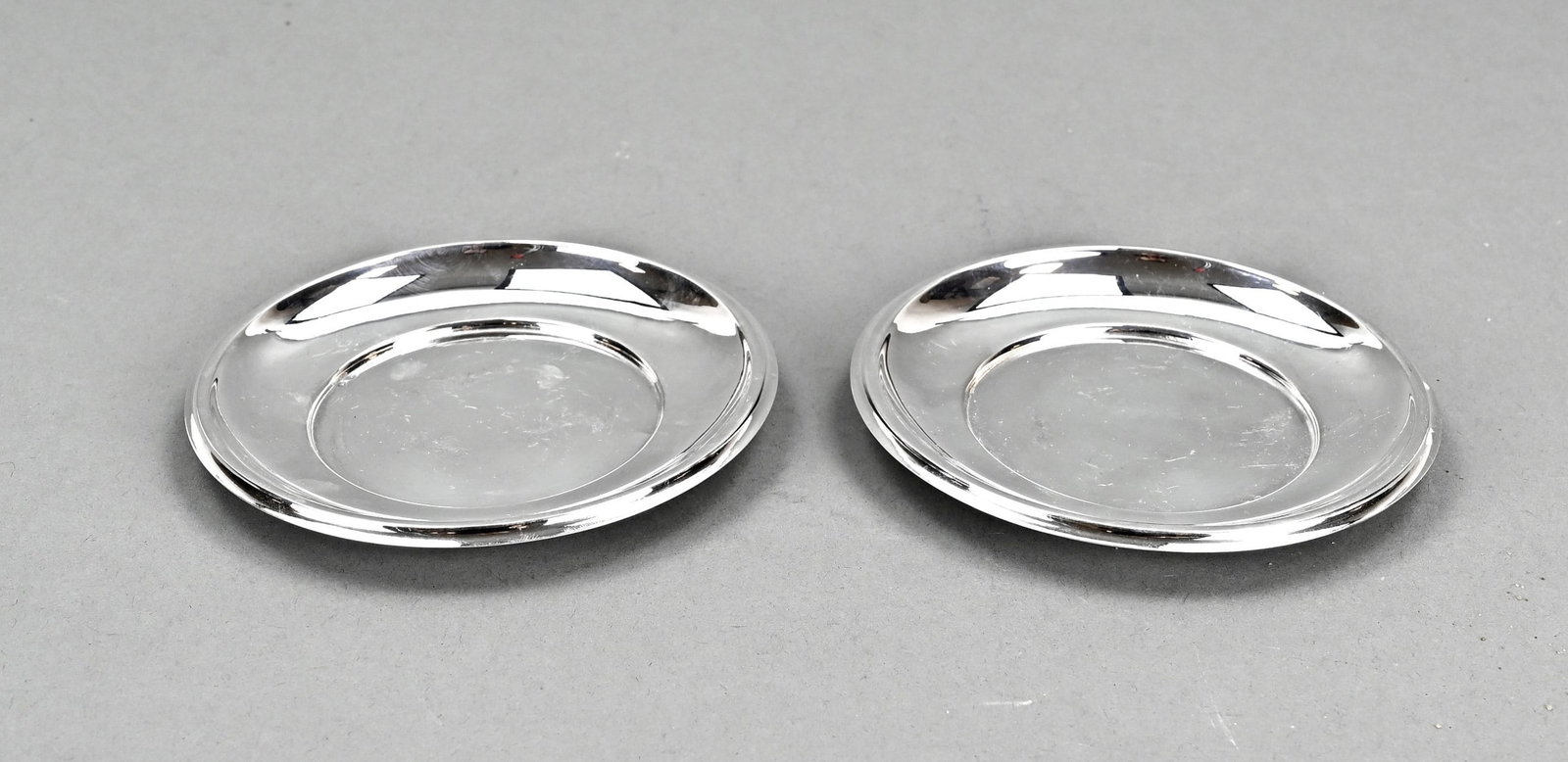 2 silver saucers: Two round silver plates/wine bottle coasters, 835/000, ø12cm. Total approx. 98 grams. In good condition.