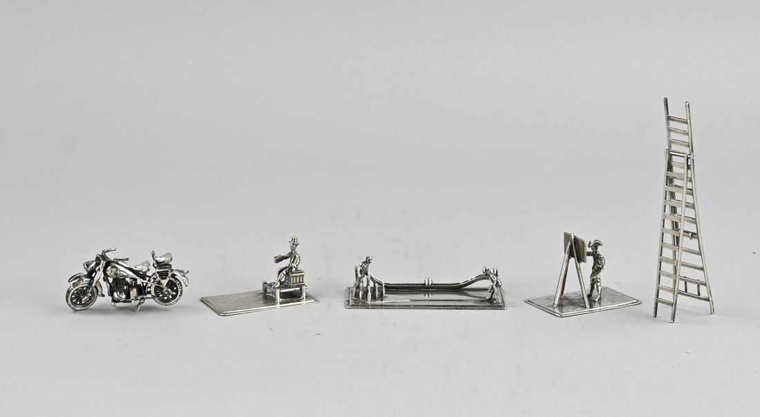 4 Silver miniatures, 1 plated: Lot of 4 silver miniatures, 835/000, featuring a painter, a figure on a chest, figures on a bowling alley, and a miniature in the shape of a motorcycle, 925/000. Also a plated miniature in the shape